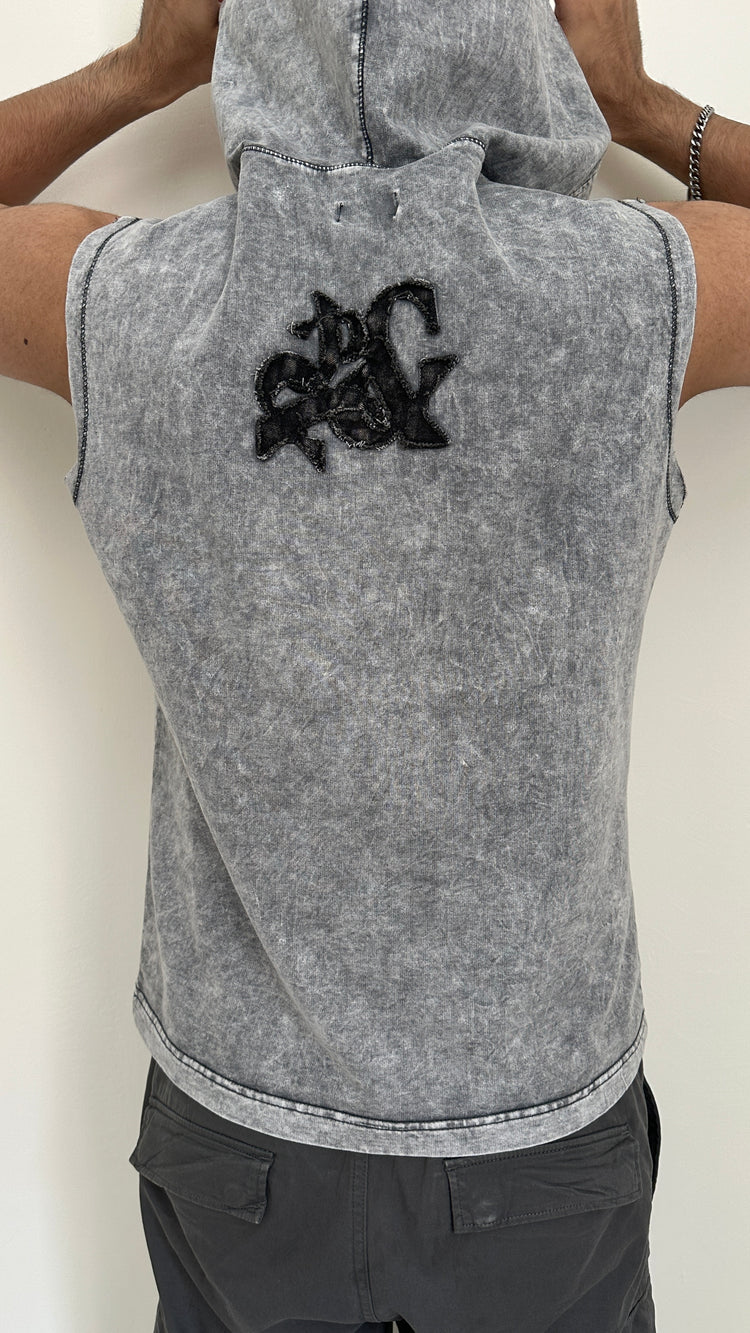 Gray sleeveless hoodie with a black logo on the back, worn by a person.
