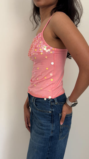 Model wearing peach sequinned camisole, side profile