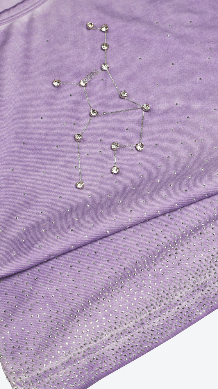 Purple fabric with a star constellation design made of small beads or stones.