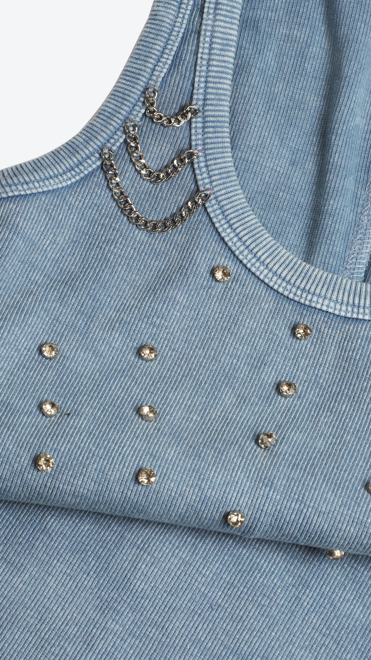 Close-up of a blue denim top with rhinestone embellishments and chains.