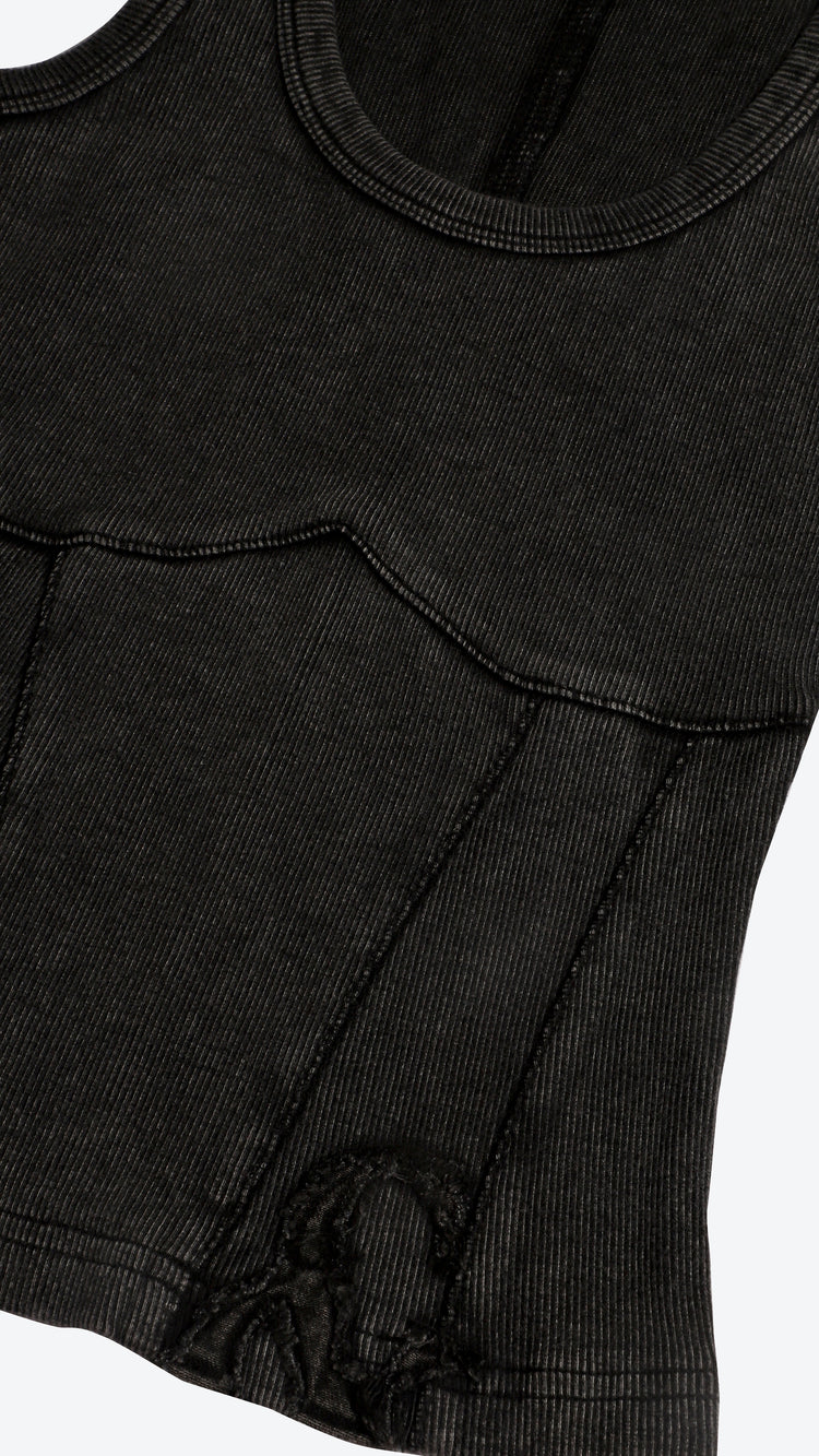 Close-up of a black garment with a brand logo detail on a white background