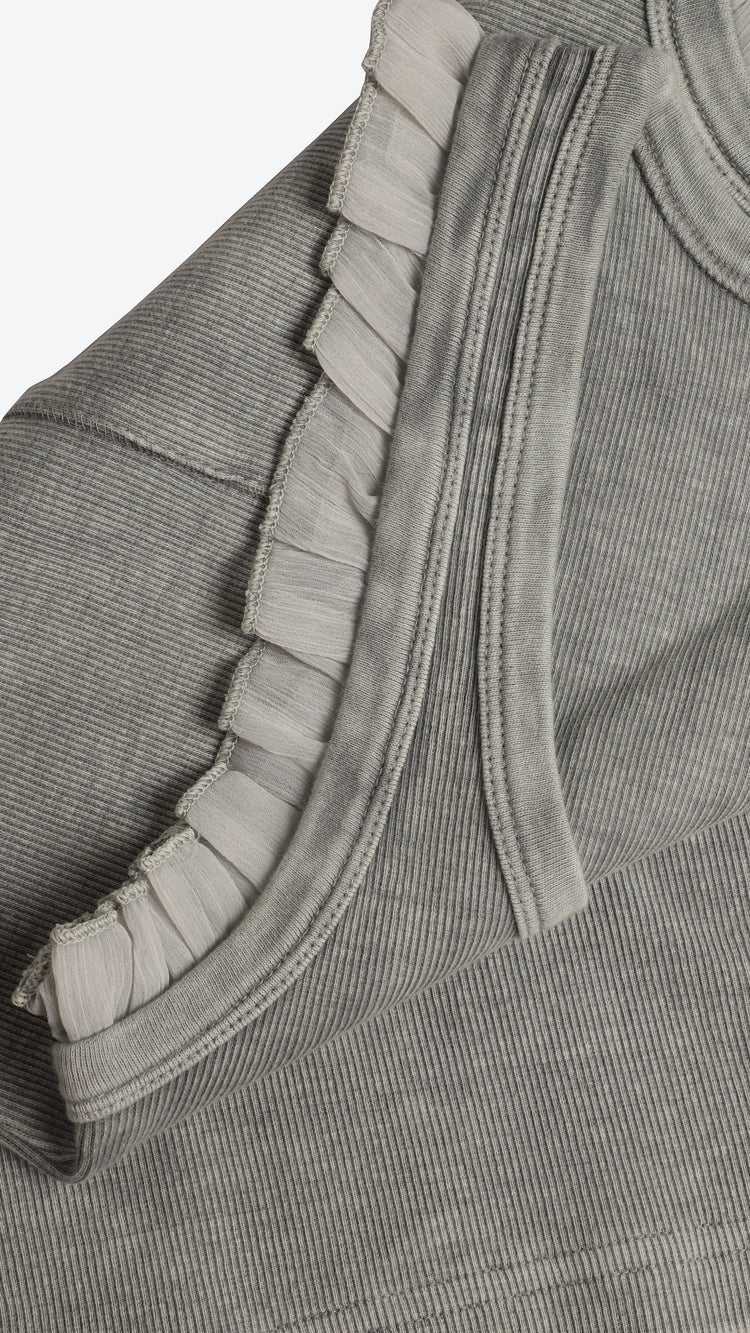 Close-up of a gray garment with ruffled details on a white background