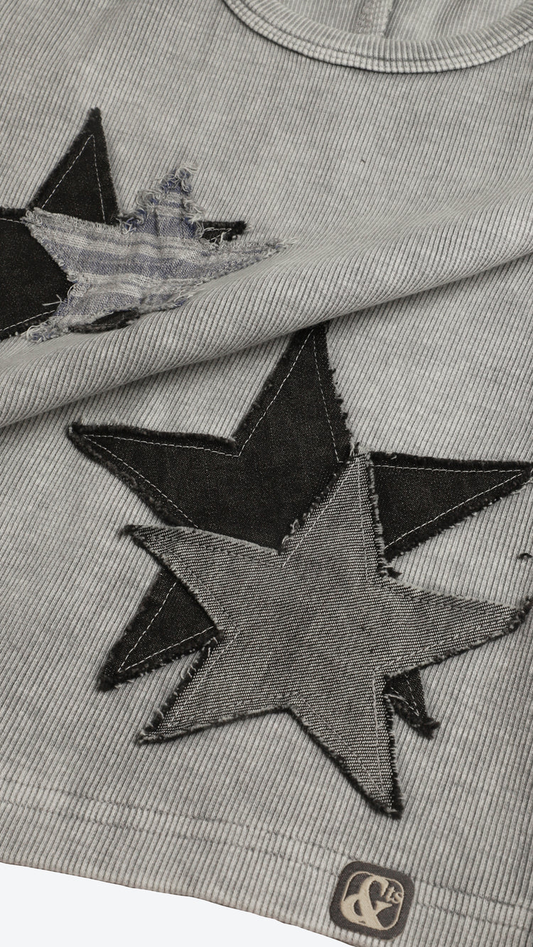 Gray fabric with black star-shaped patches and a visible brand logo.
