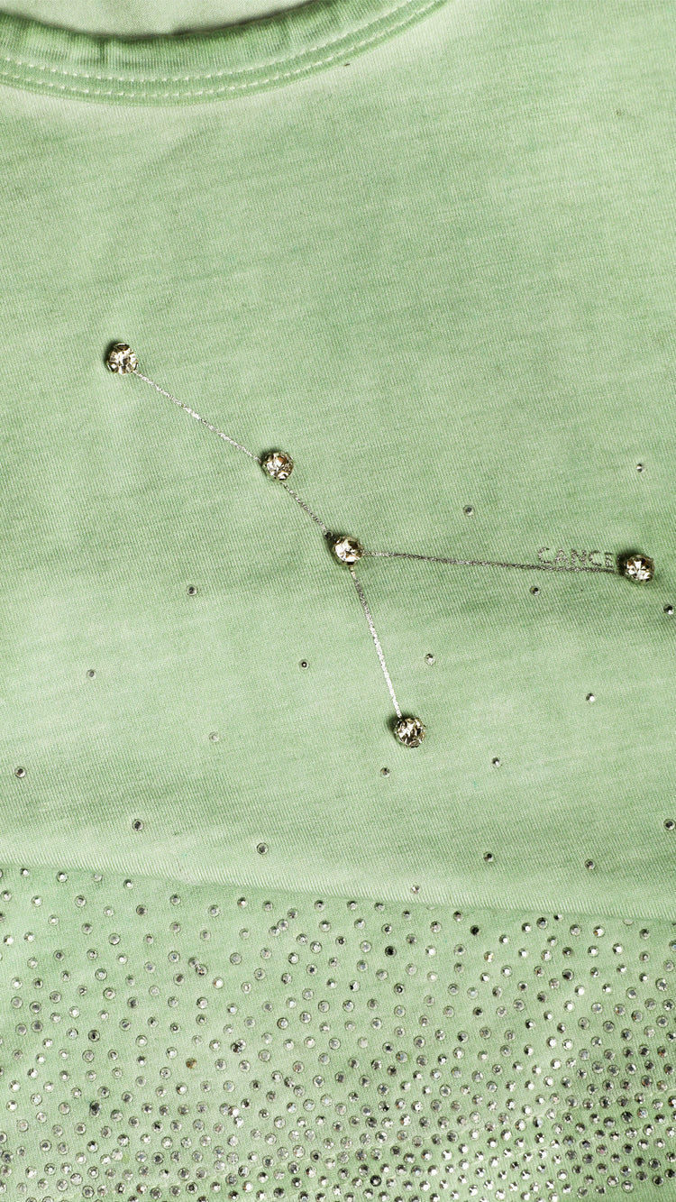 Close-up of a green tank top with a cancer constellation design.