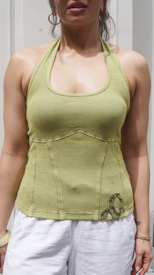 Woman wearing a green ribbed halter neck tank top with a logo on a white background