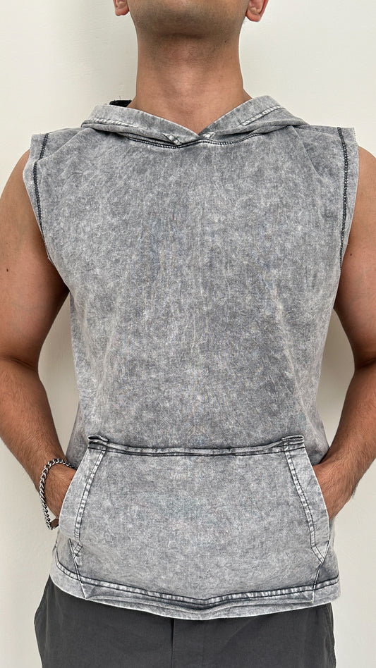 Person wearing a sleeveless gray hoodie against a plain background