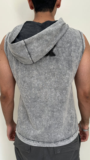 Person wearing a sleeveless gray hoodie against a plain background