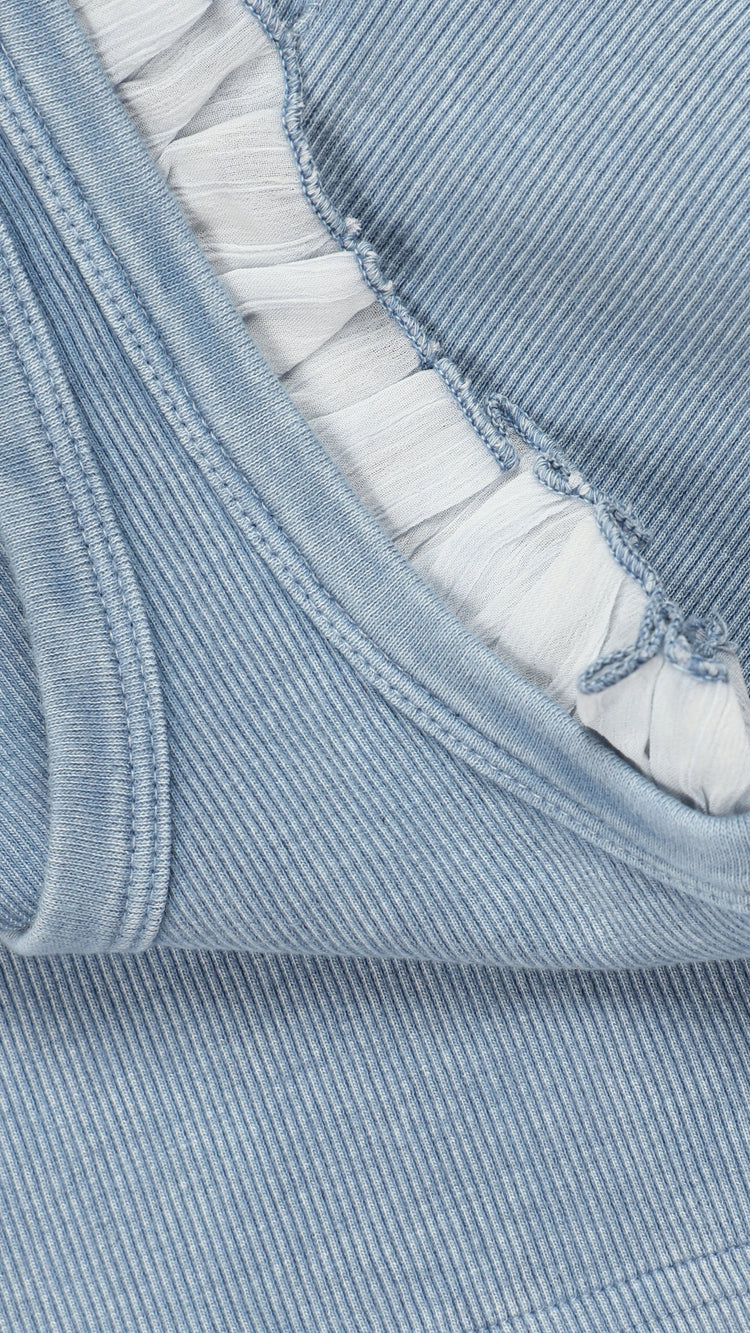 Close-up of light blue denim blue tank top with white frill detailing
