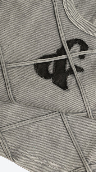 Detailed shot of a gray tank top with a black logo on a white background