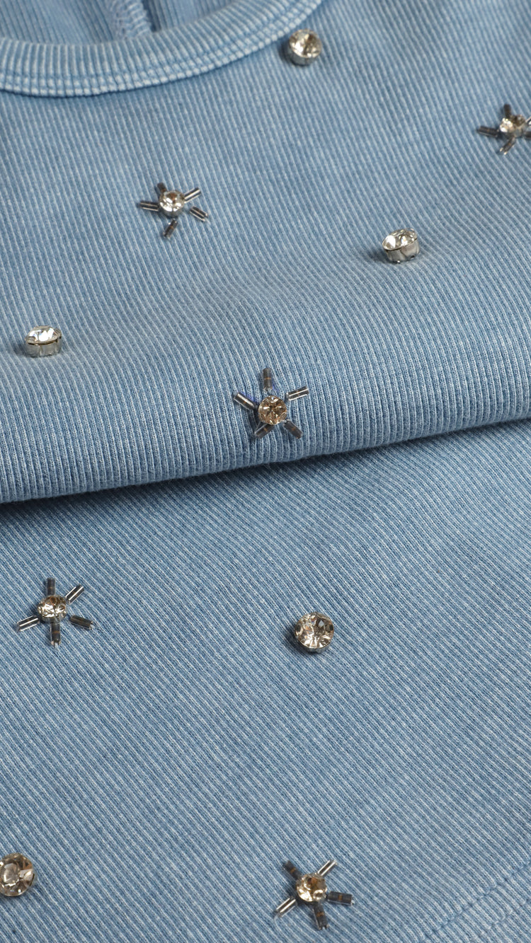Close-up of a blue tank top with decorative studs 